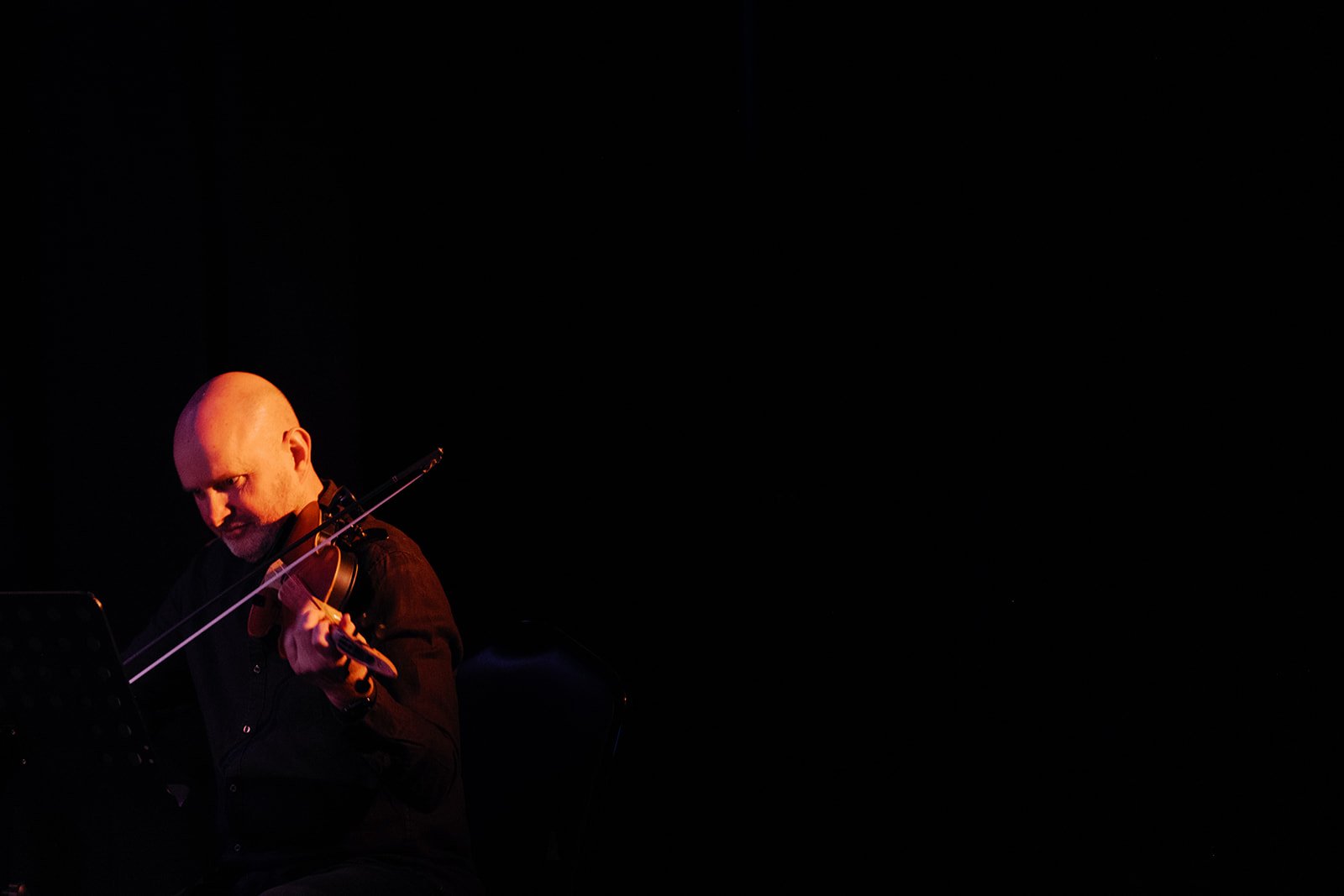Julian Ferraretto performing live, stage lit in warm tones