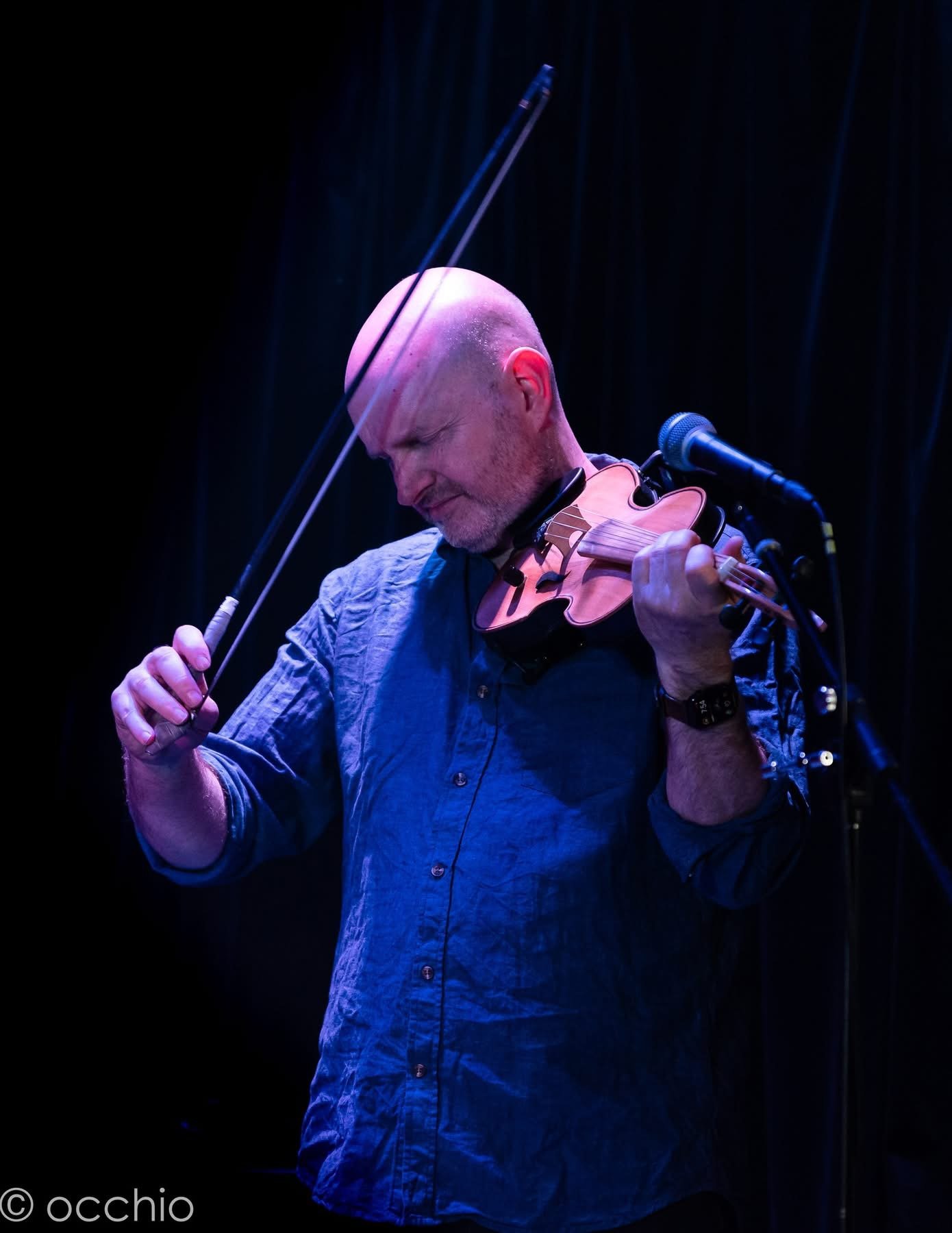 Julian Ferraretto performing under blue stage light
